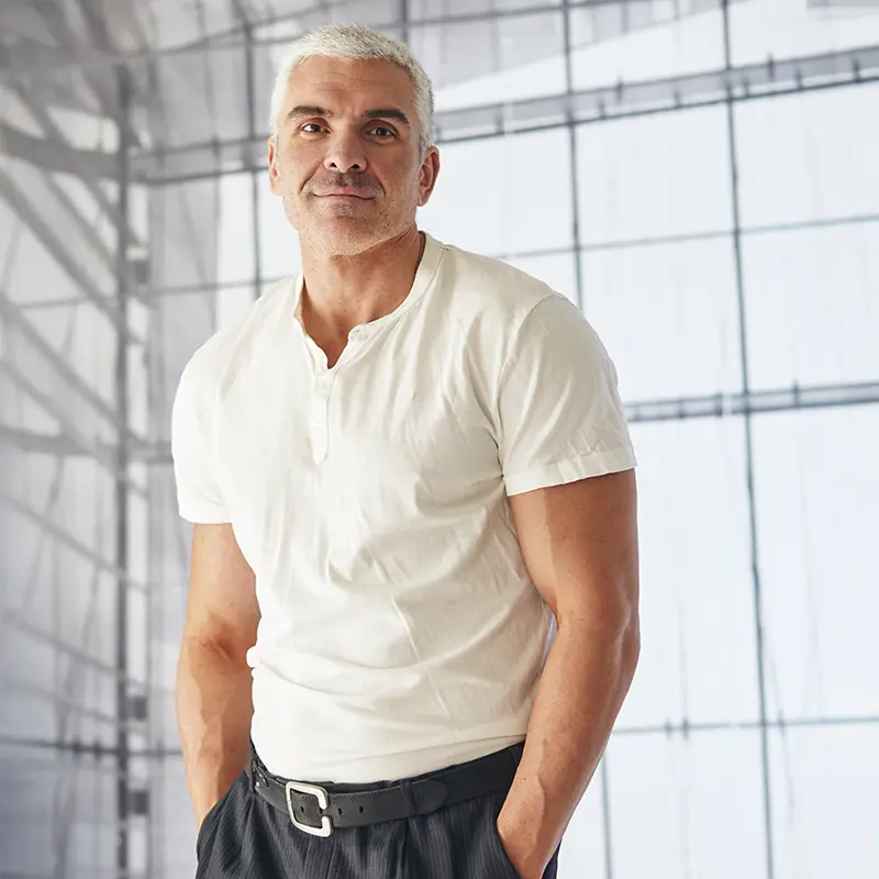 Older man posing and smiling,
